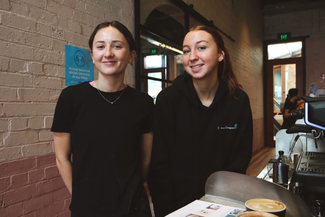 two hospitality students working in front of coffee machine